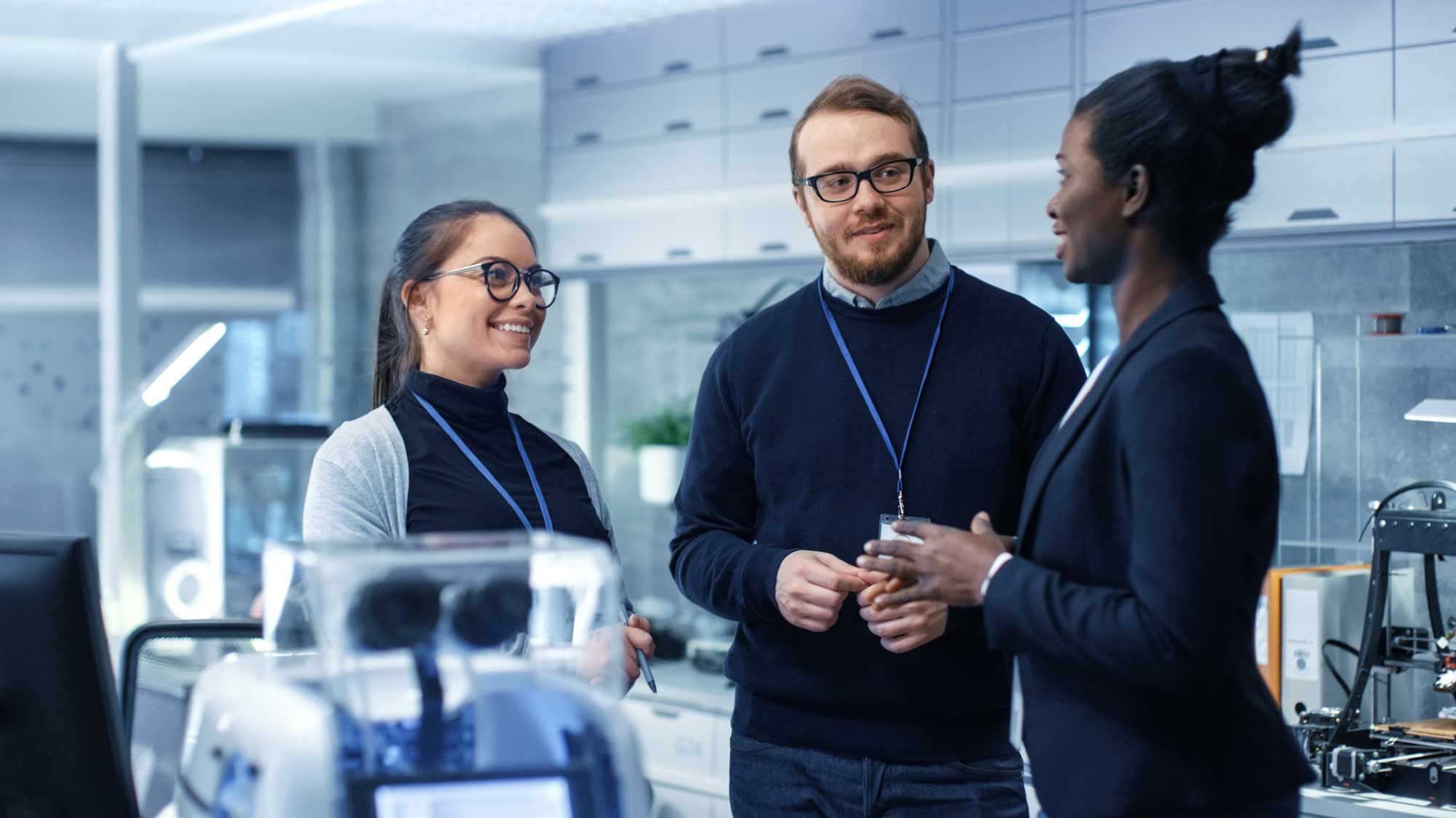Three leading scientists discussing their research in a lab