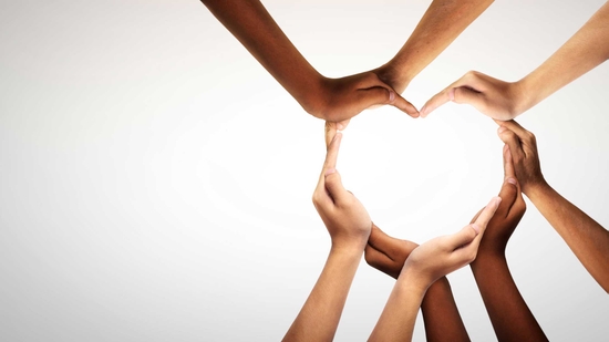 Hands of many people making up a heart shape