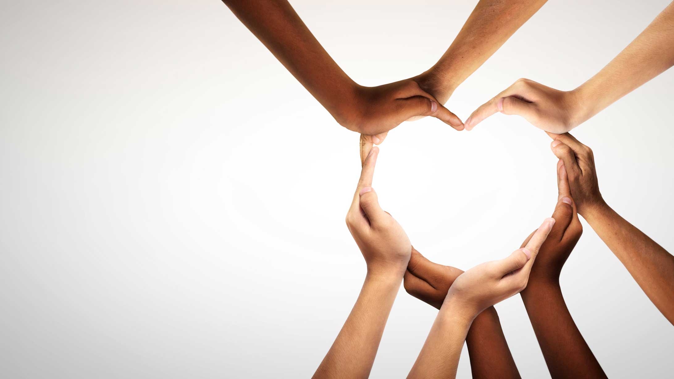 Hands of many people making up a heart shape