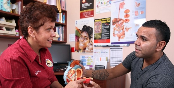 A man and woman sit in a room, examining a medical chart.